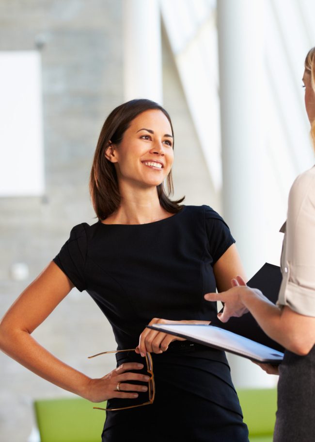 Two Businesswomen Having Informal Meeting In Modern Office